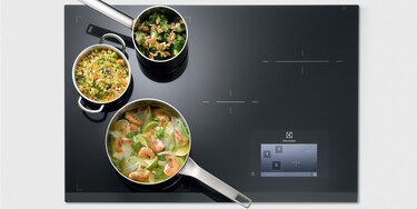 Tre kastruller inom FreeZone på en Electrolux Infinite Combi induktionshäll